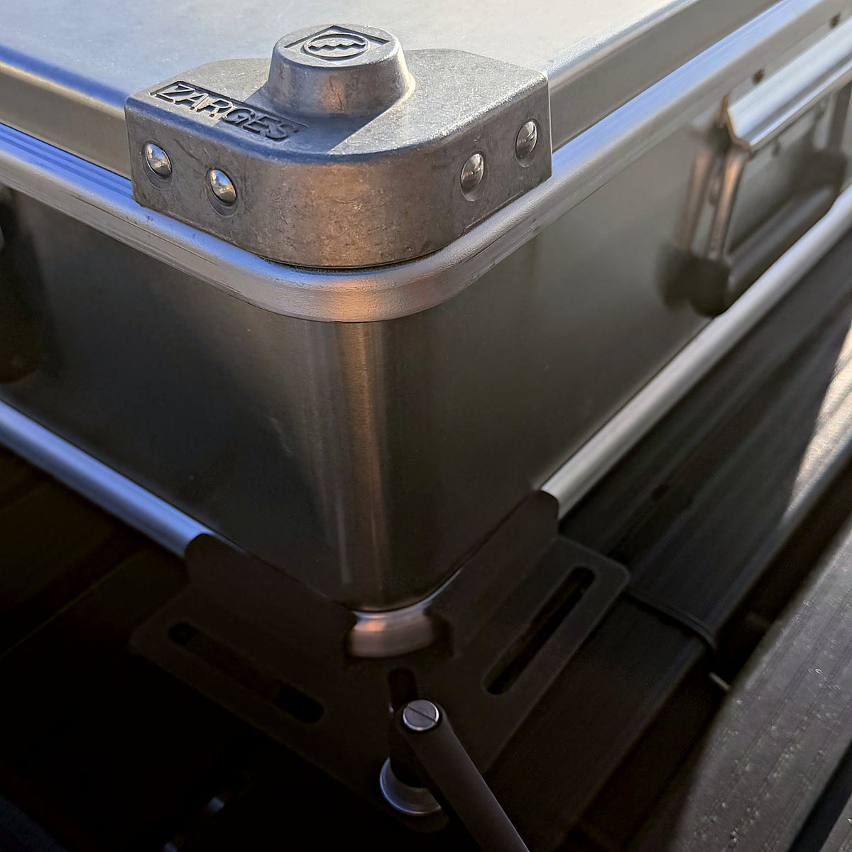ZARGES roof rack mounting hardware securing a case corner to a Front Runner rack